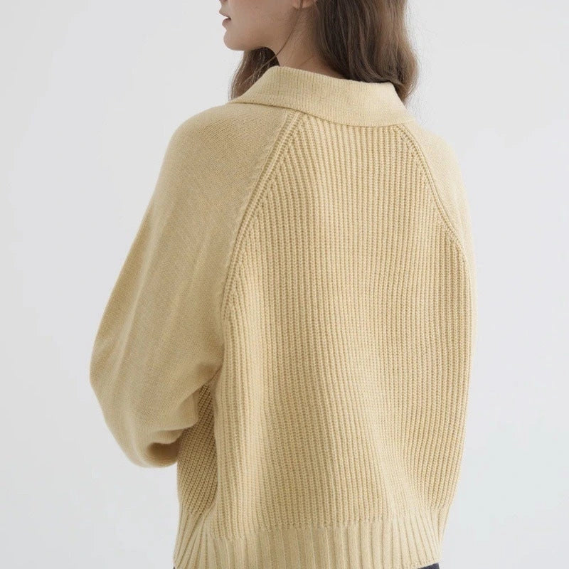 Woman wearing a yellow button-up collared sweater, back view
