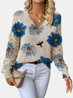 Woman wearing a blue floral v-neck long sleeve sweater in a studio setting