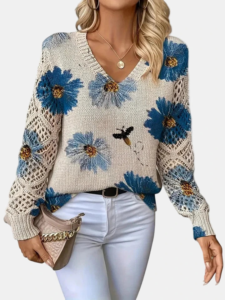 Woman wearing a blue floral v-neck long sleeve sweater in a studio setting