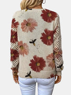 Woman wearing a red floral v-neck long sleeve sweater in a casual indoor setting