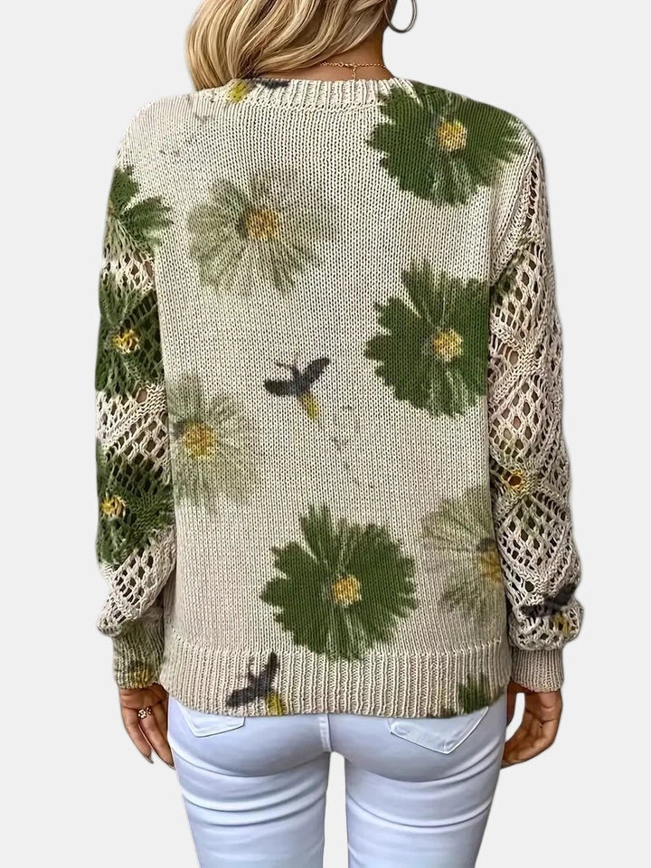 Woman wearing a green floral v-neck long sleeve sweater in a lifestyle setting, seated pose