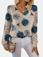 Woman wearing a blue floral v-neck long sleeve sweater, three-quarter view in a studio setting