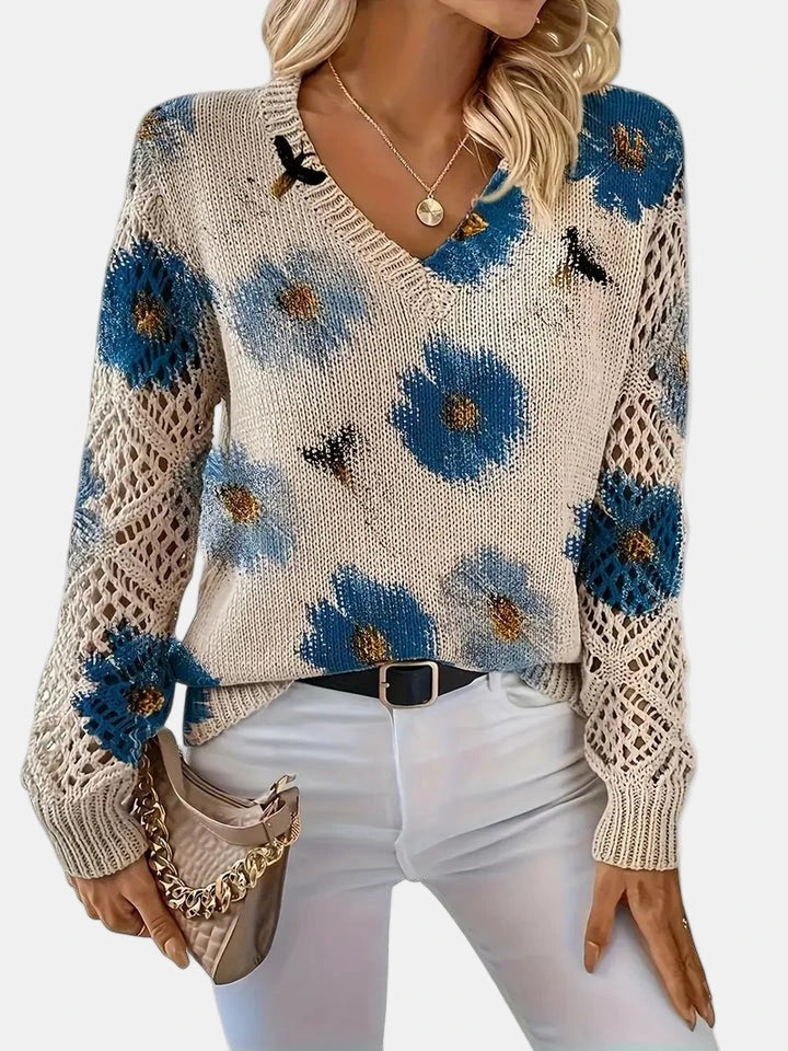 Woman wearing a blue floral v-neck long sleeve sweater, three-quarter view in a studio setting