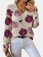 Woman wearing a purple floral v-neck long sleeve sweater in a lifestyle cafe setting
