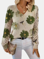 Woman wearing a green floral v-neck long sleeve sweater in an outdoor urban setting