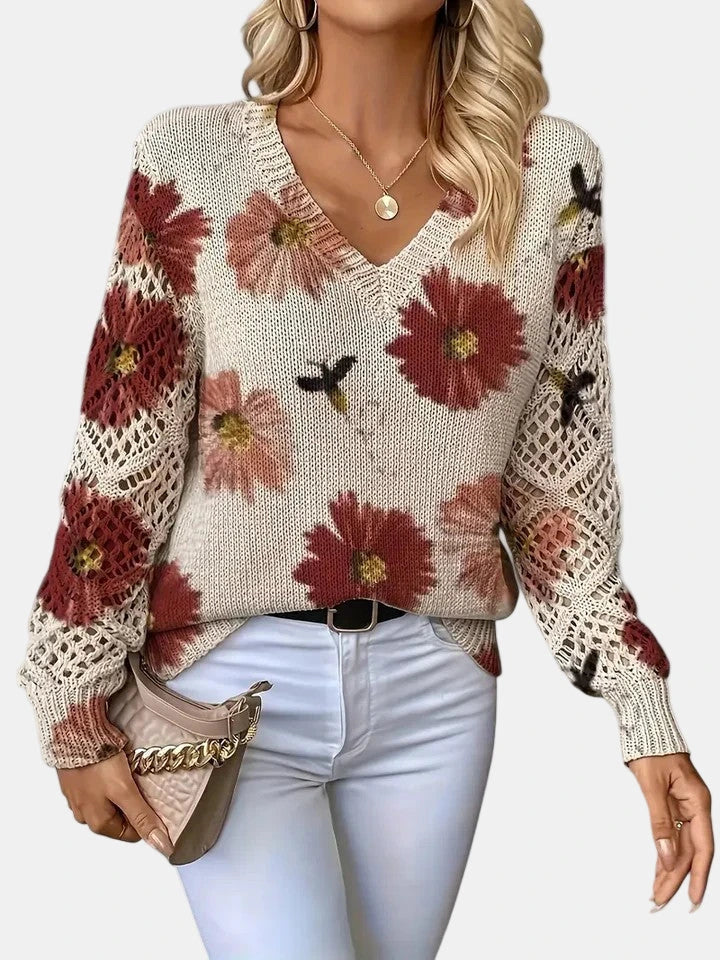 Woman wearing a red floral v-neck long sleeve sweater in an outdoor setting
