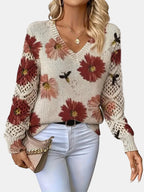 Woman wearing a red floral v-neck long sleeve sweater in an outdoor setting