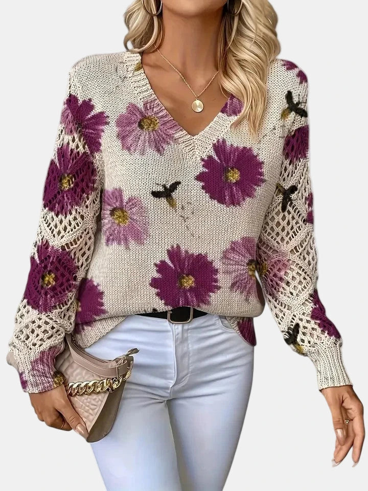 Close-up of a purple floral v-neck long sleeve sweater showing the floral print detail