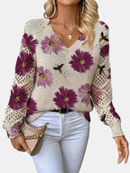Close-up of a purple floral v-neck long sleeve sweater showing the floral print detail