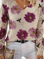Woman wearing a purple floral v-neck long sleeve sweater, front view in a studio setting