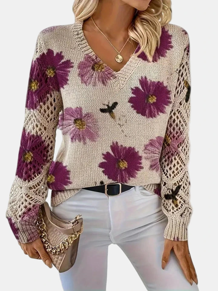 Woman wearing a purple floral v-neck long sleeve sweater, back view in a studio setting