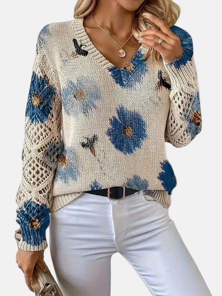 Woman wearing a blue floral v-neck long sleeve sweater, side profile in an outdoor setting