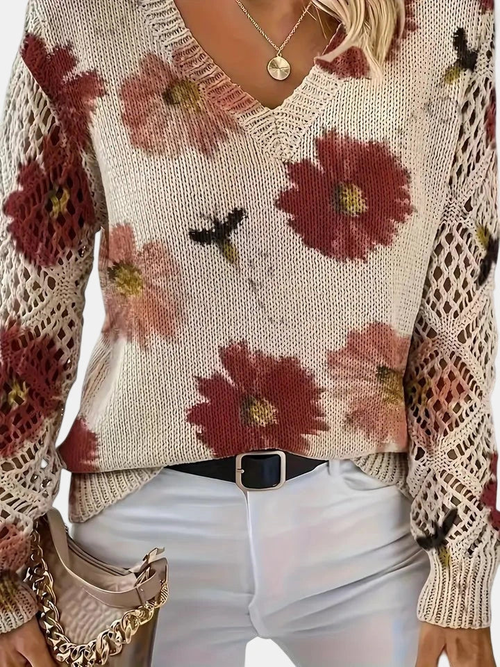 Full-length view of a woman wearing a red floral v-neck long sleeve sweater outdoors