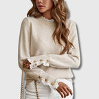 Woman wearing an apricot lace trim round neck long sleeve sweater in a lifestyle setting