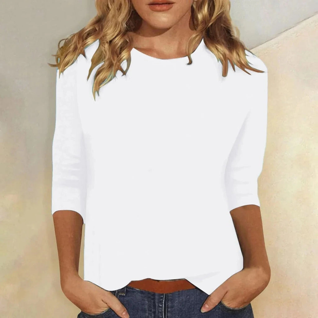 Woman wearing a white crew neck three-quarter sleeve top in a studio setting