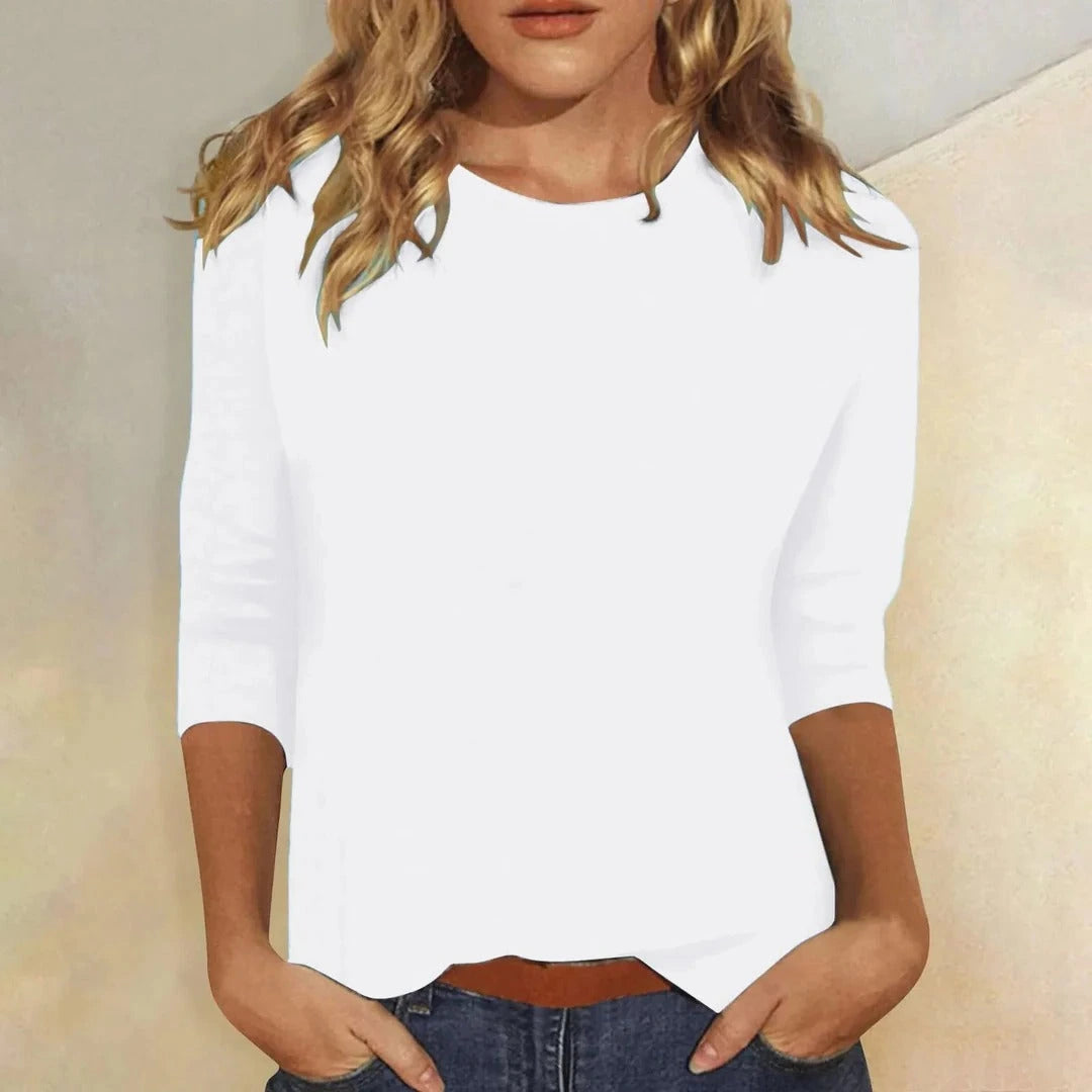 Woman wearing a white crew neck three-quarter sleeve top in a studio setting