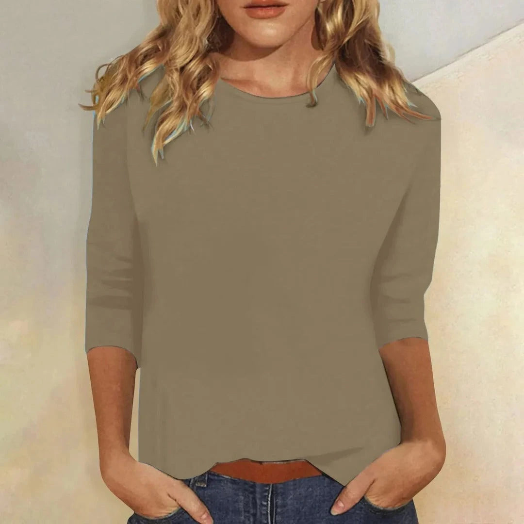 Woman wearing a khaki crew neck three-quarter sleeve top in a studio setting