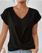 Woman wearing a black v-neck twist front short sleeve top in a studio setting