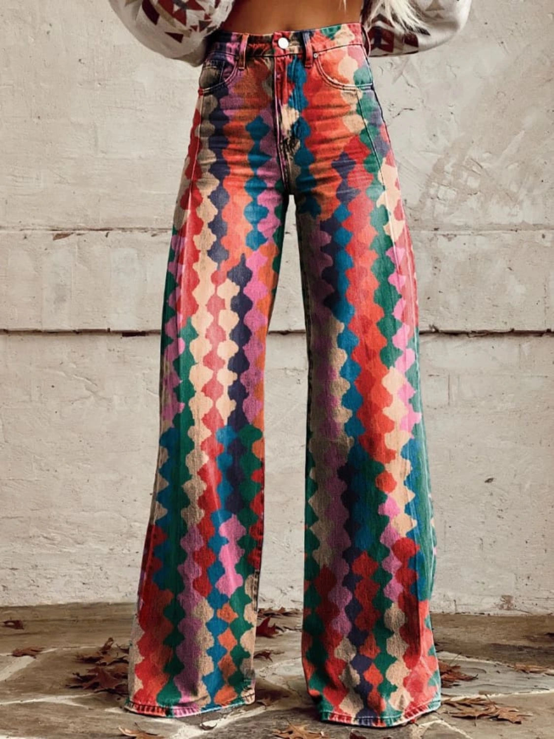 Woman wearing multicolor bohemian chic high-waisted wide-leg trousers with a geometric diamond print, close-up front view