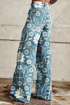Woman wearing blue bohemian print wide-leg trousers with a white daisy floral pattern, back view