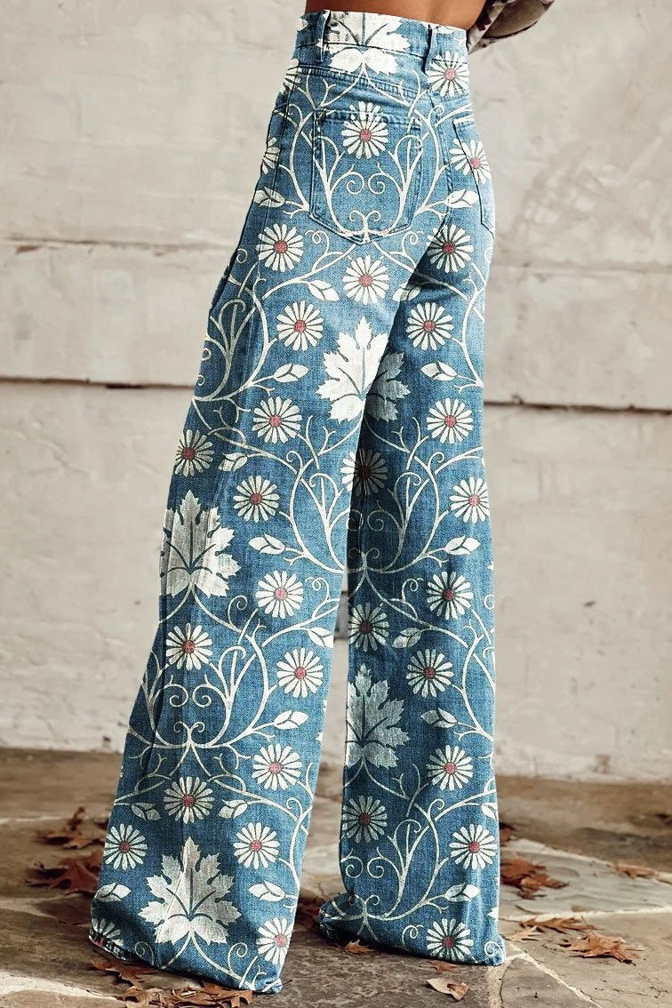 Woman wearing blue bohemian print wide-leg trousers with a white daisy floral pattern, back view