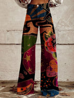 Woman wearing red and black bohemian print wide-leg trousers with gold star and floral details, front view