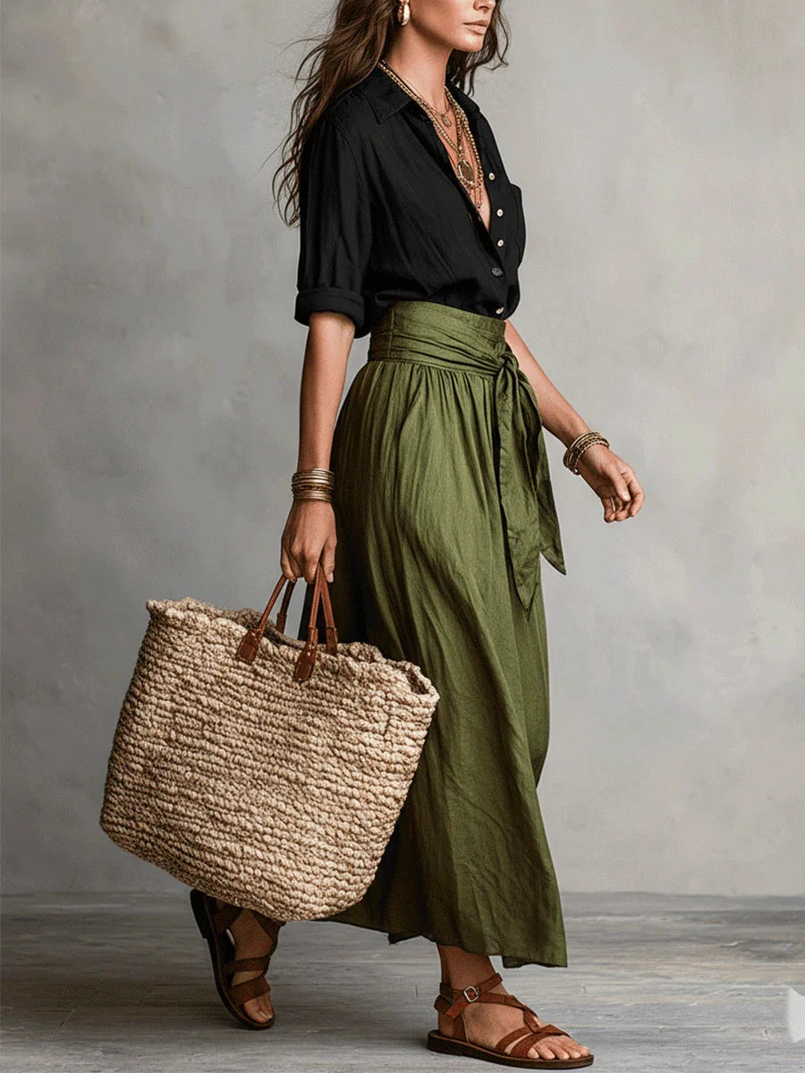 Woman wearing a black and olive green two-piece midi set in an outdoor setting