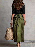 Woman wearing a black and olive green two-piece midi set in a lifestyle setting